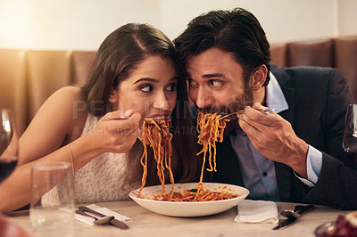 Buy stock photo Hungry, restaurant and couple eating spaghetti for love, crazy fun and sharing plate on valentines date celebration. Happy people with pasta food for anniversary, dinner or fine dining experience