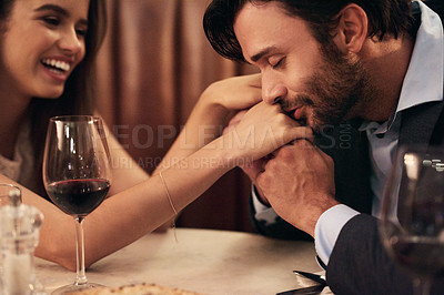 Buy stock photo Hand, kissing and love with a couple in a restaurant on a date night out together for fine dining or luxury. Love, romance and affection with a man and wife sharing a kiss while dating in celebration