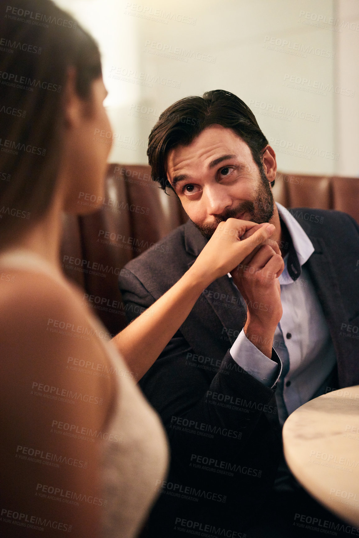 Buy stock photo Hand, kiss and love with a couple in a restaurant on a date night out together for fine dining or luxury. Love, romance and affection with a man kissing his wife while dating in celebration