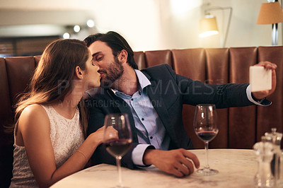 Buy stock photo Kiss, selfie and romantic couple fine dining at a luxury restaurant with love, care and happiness together. Lovers, people and man taking a picture with his woman on valentines day for social media