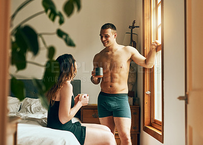 Buy stock photo Shot of a happy young couple having their morning coffee together in the bedroom at home