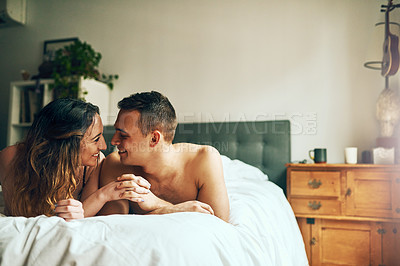 Buy stock photo Shot of an affectionate young couple spending a romantic morning in bed at home