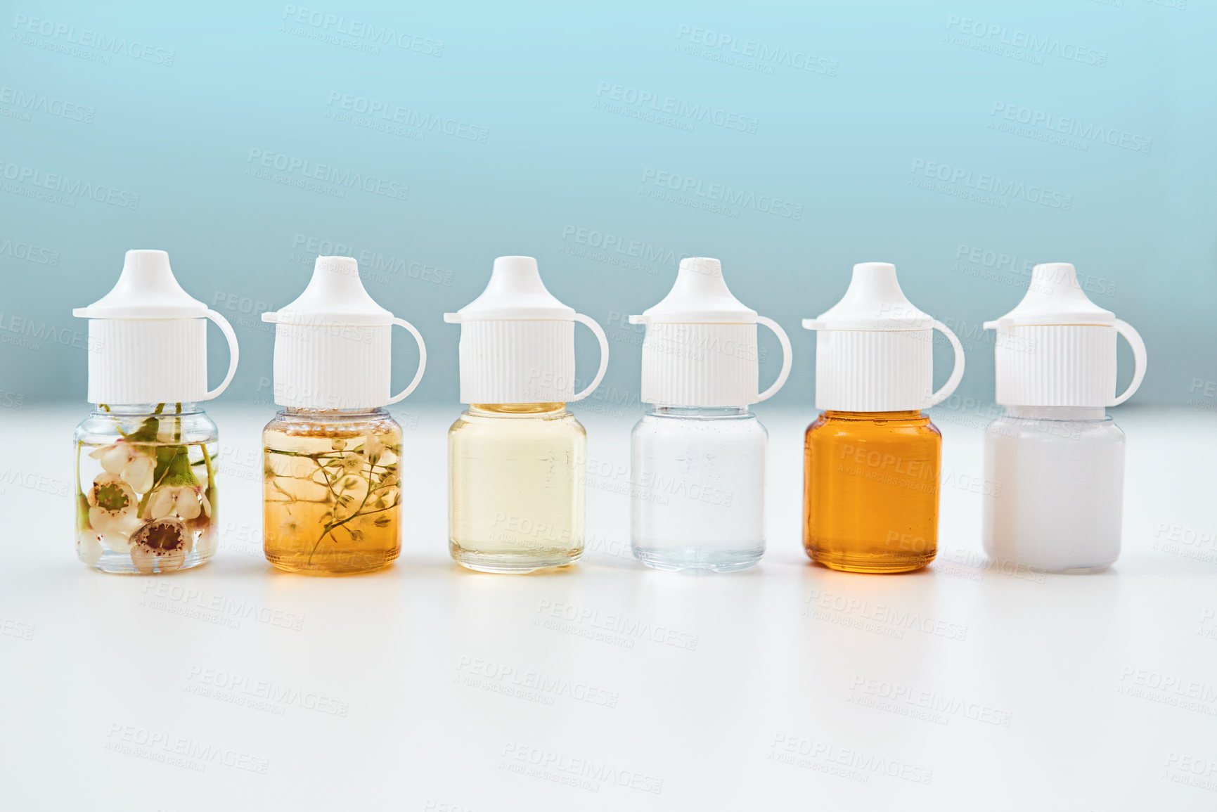 Buy stock photo Studio shot of alternative forms of medication lined up on a table against a blue background
