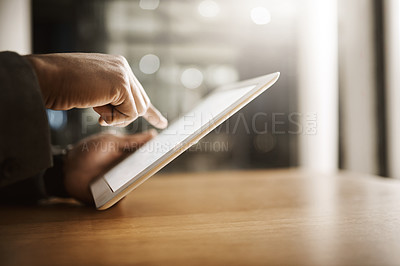 Buy stock photo Cropped shot of an unrecognizable businessperson browsing on a digital tablet inside of the office during the day