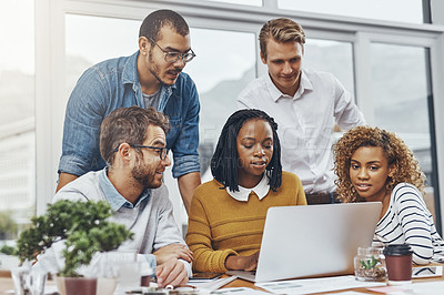 Buy stock photo Cropped shot of a group of businesspeople looking at something on a laptop