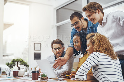 Buy stock photo Low angle shot of a group of businesspeople looking at something on a laptop