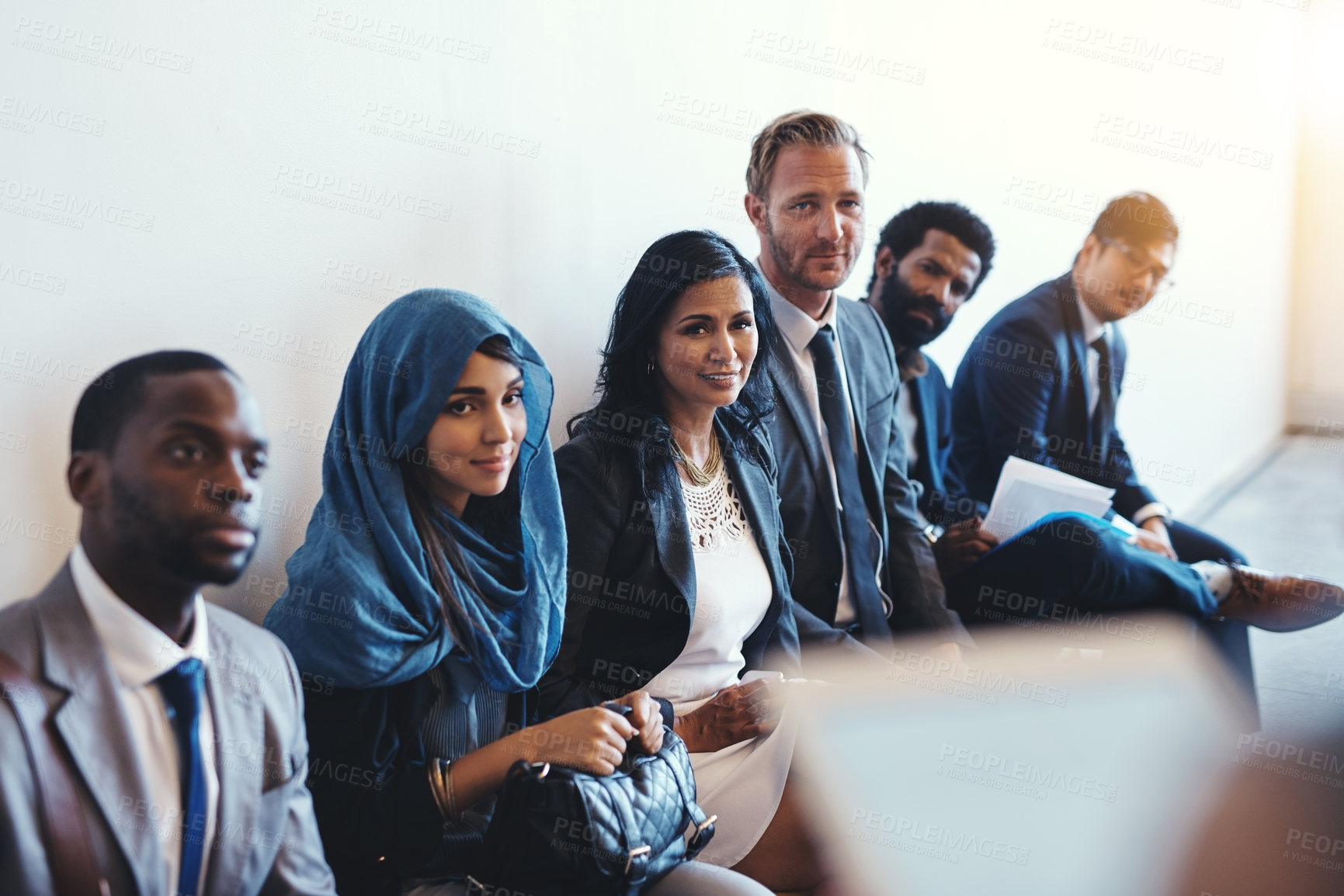 Buy stock photo Shot of a group of confident businesspeople waiting in line for their interviews inside of a office during the day