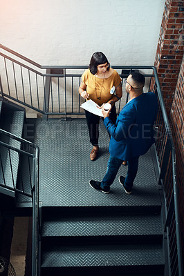 Buy stock photo Shot of two designers having a discussion on a staircase in an office