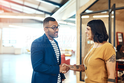 Buy stock photo Shot of two designers shaking hands in an office