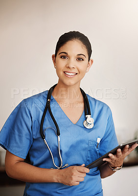 Buy stock photo Cropped portrait of an attractive young female medical practitioner working on a digital tablet in a hospital