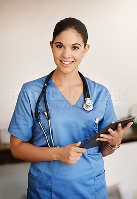 Buy stock photo Cropped portrait of an attractive young female medical practitioner working on a digital tablet in a hospital