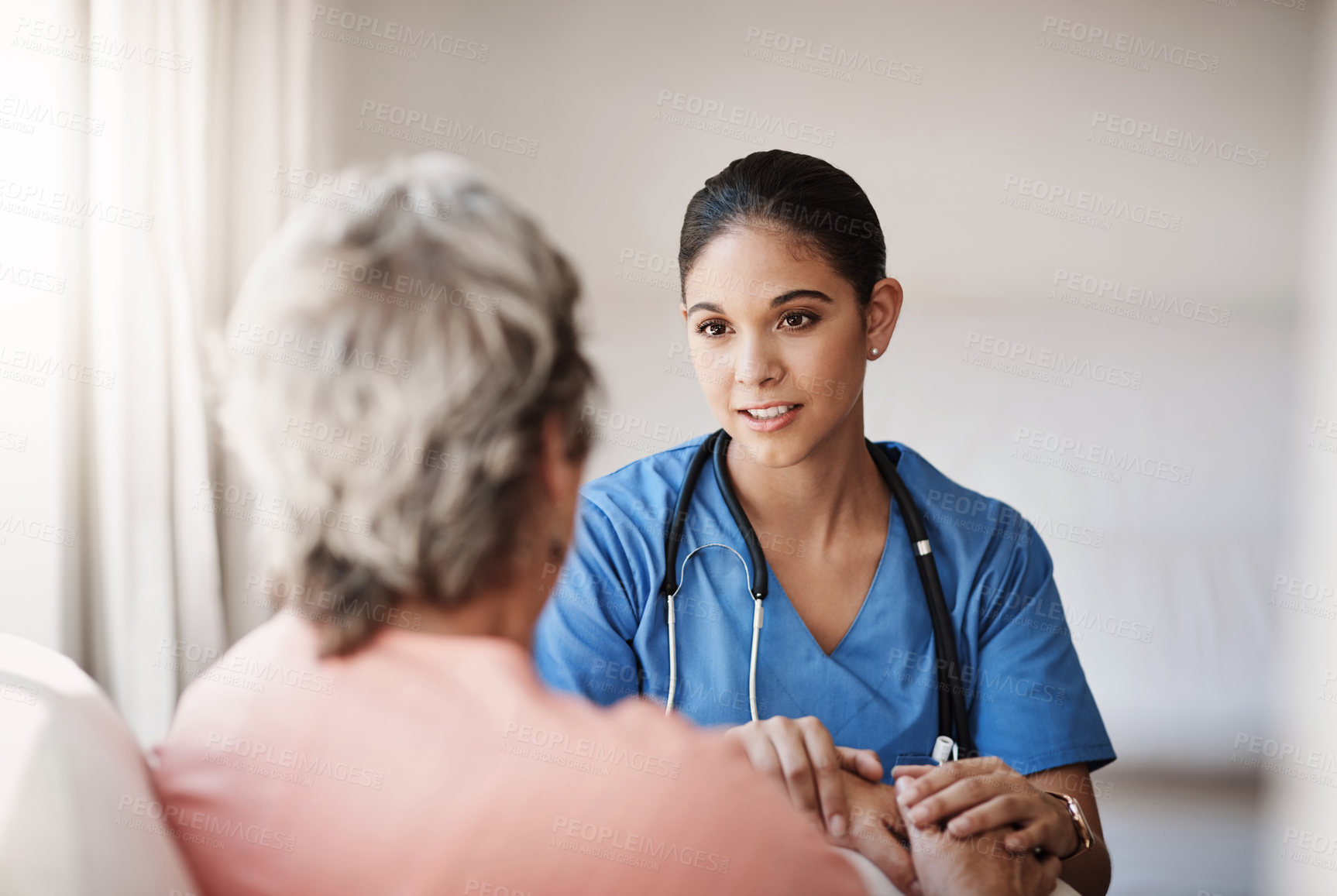 Buy stock photo Cropped shot of an attractive young nurse holding a senior woman's hands in comfort