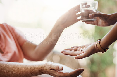 Buy stock photo Cropped shot of an unrecognizable nurse giving medication and a glass of water to a patient