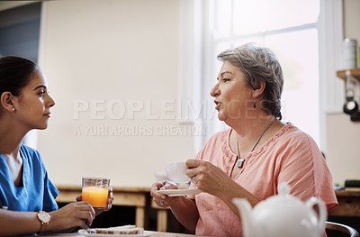 Buy stock photo Caregiver, woman and talking with tea in kitchen for breakfast, relax or support of medical consultation. Nurse, patient and advice for senior care by helping, trust or wellness at nursing home