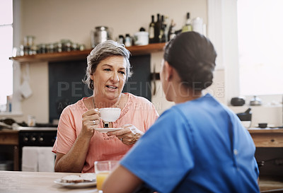 Buy stock photo Senior woman, nurse and kindness in kitchen for consultation, therapy and mental health. Tea, discussion and retired female person with medical worker or caregiver in home for conversation and advice