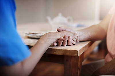 Buy stock photo People, holding hands or help in nursing home for support, empathy or hope in living room. Caregiver, woman or elderly care at wooden table for grief counselling, trust or mental health in retirement