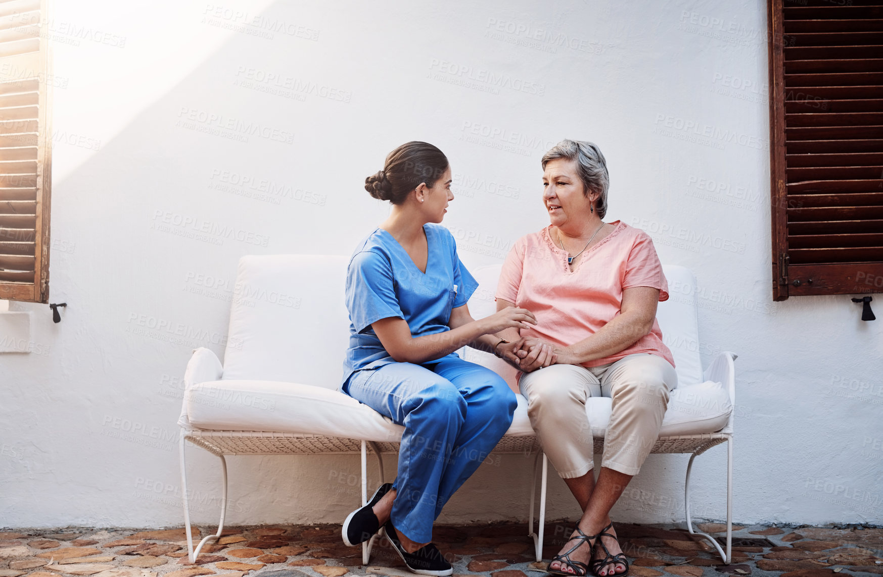 Buy stock photo Holding hands, caregiver and senior woman outdoor for therapy, kindness and mental health. Chat, discussion and medical worker or nurse with retired female person on bench for conversation and home