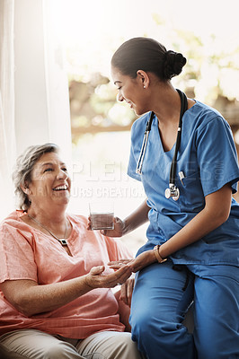 Buy stock photo Cropped shot of an attractive young female nurse giving medication and a glass of water to a senior patient
