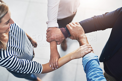 Buy stock photo High angle shot of a group of unrecognizable businesspeople joining their hands in a gesture of unity