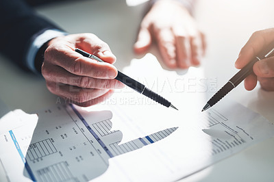Buy stock photo Cropped shot of two unrecognizable businessmen discussing paperwork at the table in the boardroom