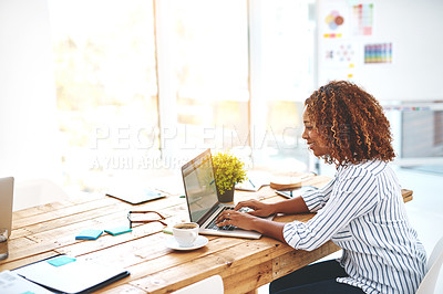 Buy stock photo Cropped shot of an attractive young woman using her laptop on a wooden table