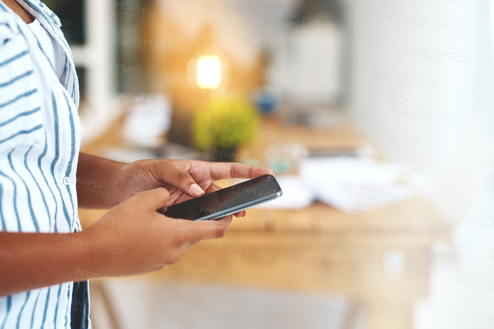 Buy stock photo Cropped shot of an unrecognizable young woman using her cellphone