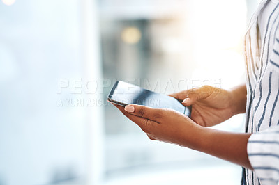 Buy stock photo Cropped shot of an unrecognizable young woman using her cellphone