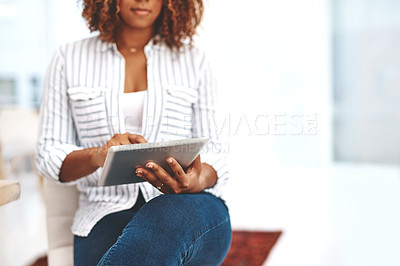Buy stock photo Female holding a tablet, scrolling the web online and social media at home. Casual woman checking emails and taking a break on the internet. Lady using modern technology to relax inside
