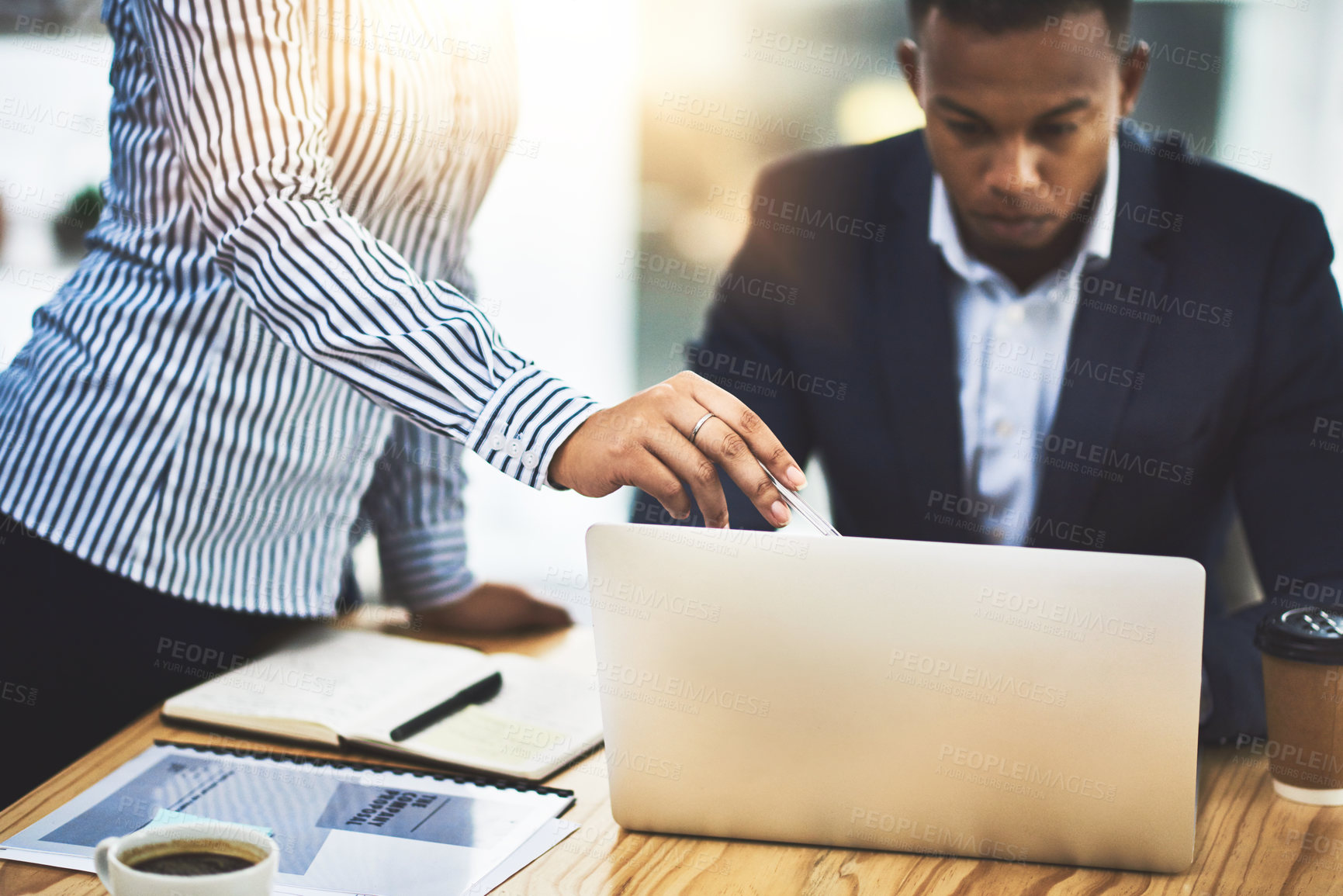 Buy stock photo Shot of two businesspeople working together on a laptop in an office