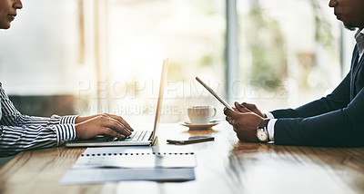 Buy stock photo Closeup shot of two businesspeople using digital devices during a meeting in an office