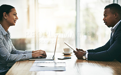 Buy stock photo Shot of two businesspeople using digital devices during a meeting in an office