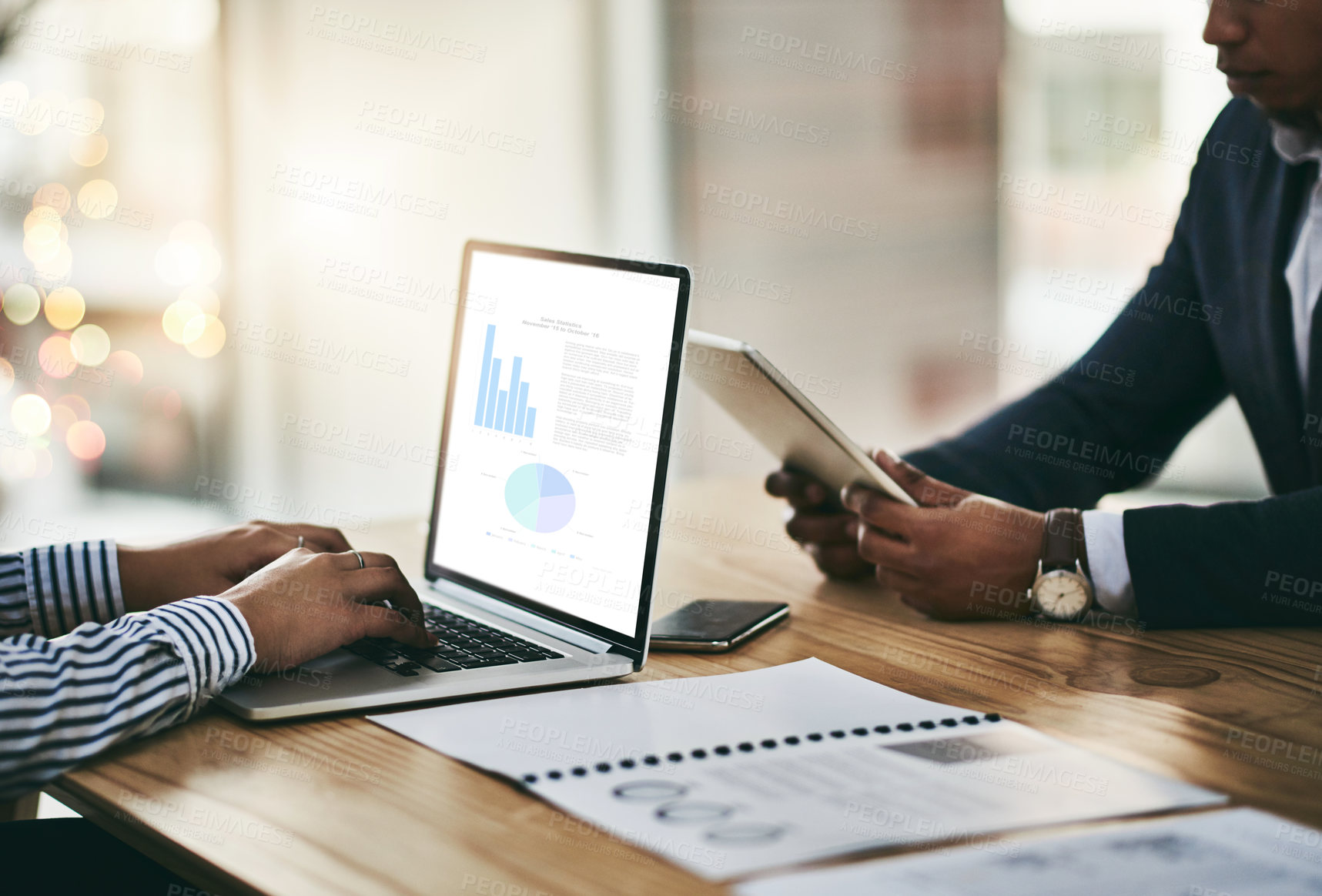 Buy stock photo Closeup shot of two businesspeople using digital devices during a meeting in an office