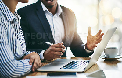 Buy stock photo Closeup shot of two businesspeople working together on a laptop in an office