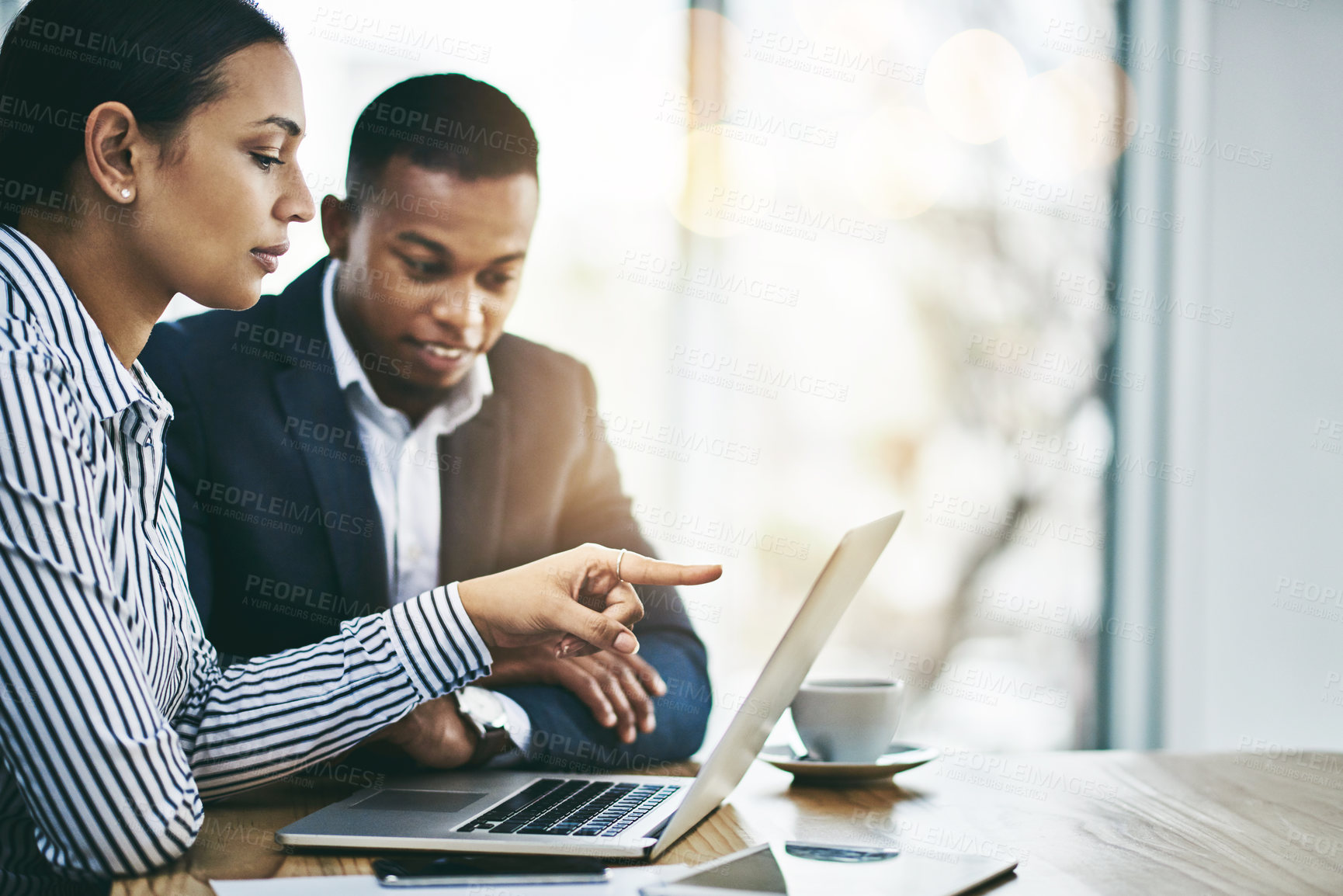 Buy stock photo Shot of two businesspeople working together on a laptop in an office