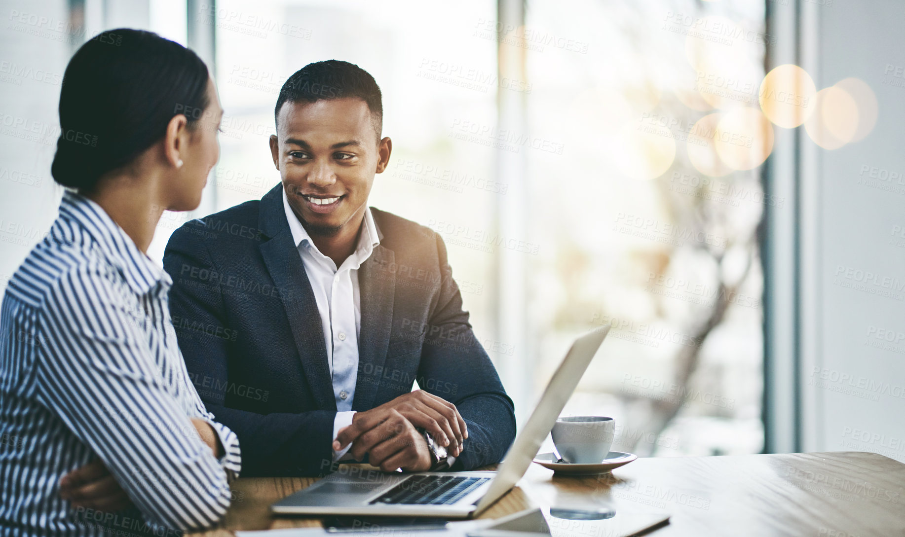 Buy stock photo Shot of two businesspeople working together on a laptop in an office