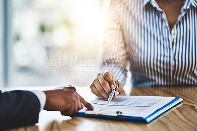 Buy stock photo Closeup shot of two businesspeople going through paperwork in an office