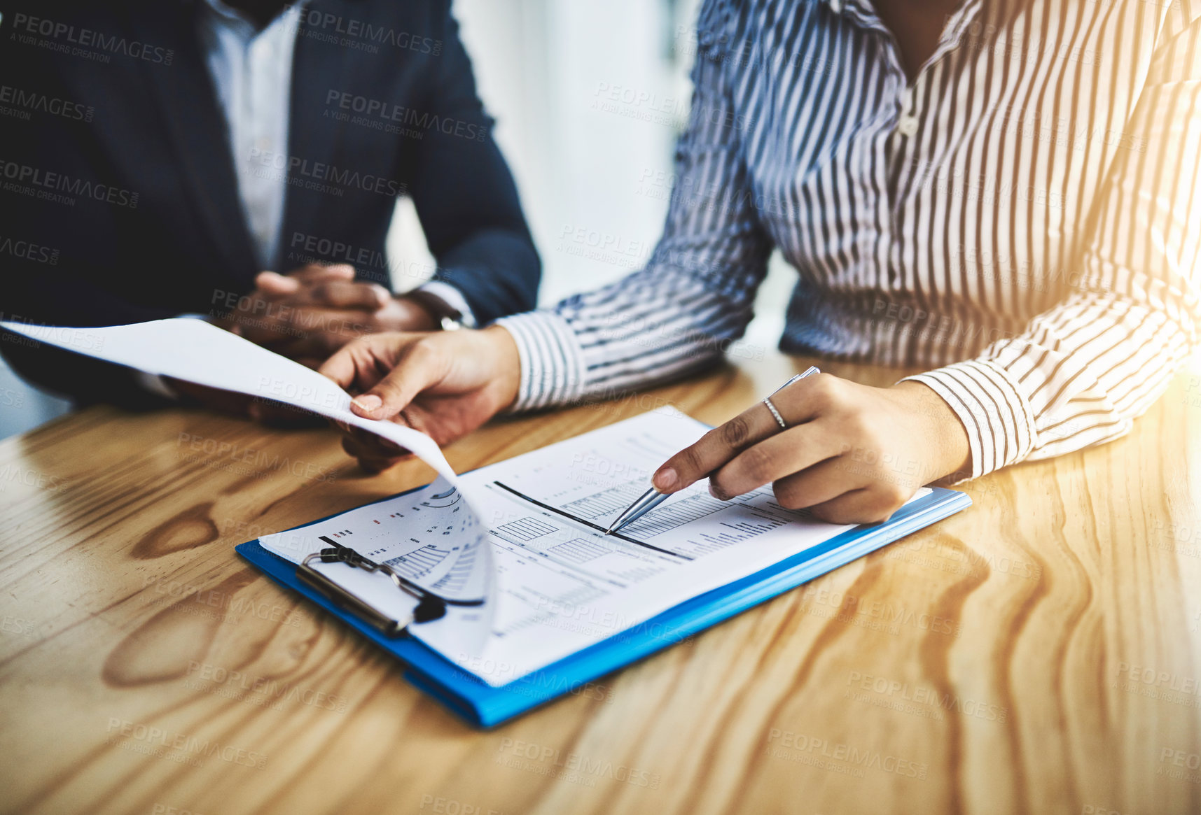 Buy stock photo Closeup shot of two businesspeople going through paperwork in an office