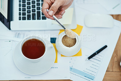 Buy stock photo Shot of an unrecognizable businessman pouring a teaspoon of sugar into a cup of tea in an office