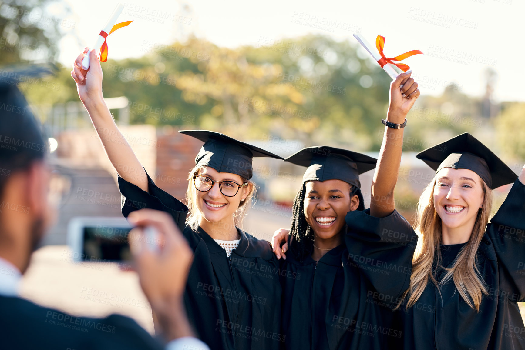 Buy stock photo People, photo and graduation outside for celebration, students and smartphone or memory picture with graduate pride. Happy, smile and together or diploma achievement, university and social media post