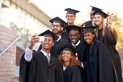 Buy stock photo Shot of a group of students taking selfies on graduation day