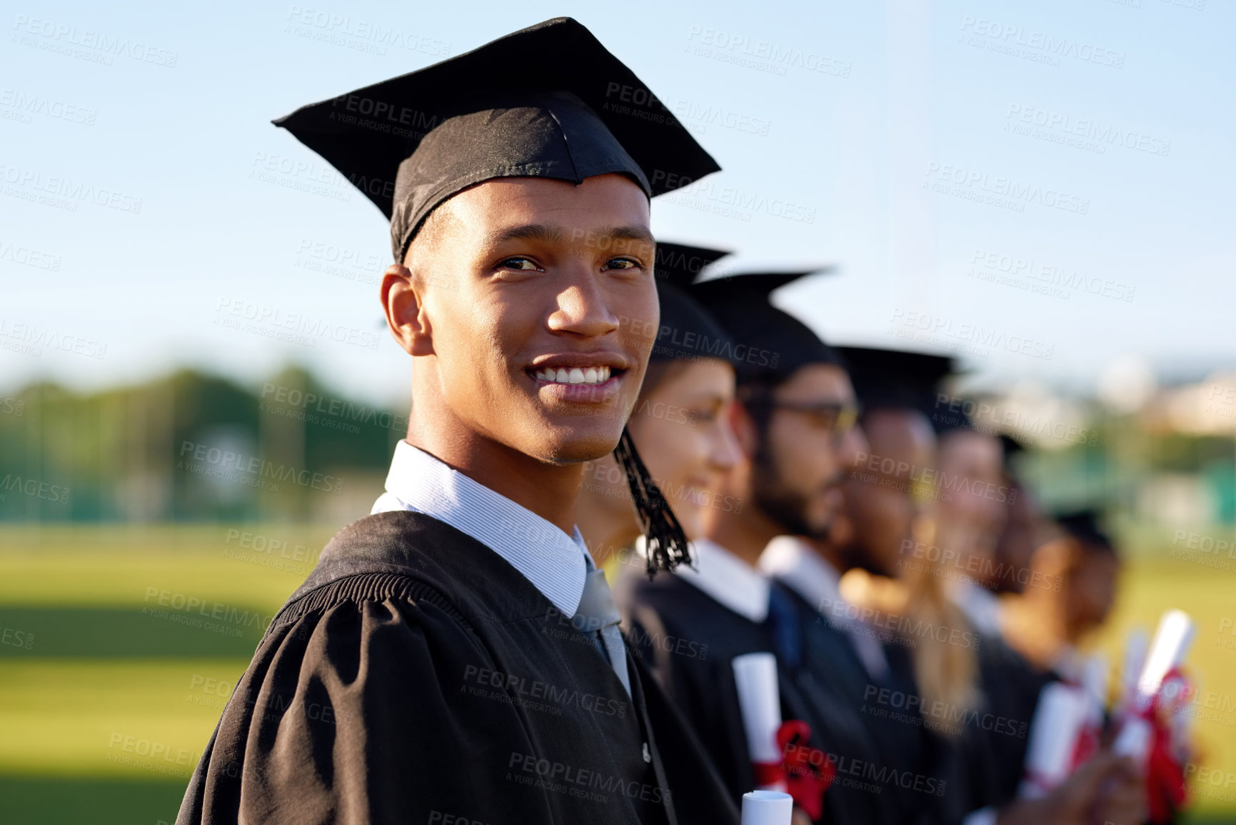 Buy stock photo Happy black man, smile and graduation class with group at ceremony for education, qualification or future. Portrait of person or scholar with students for diploma, certificate or degree on campus