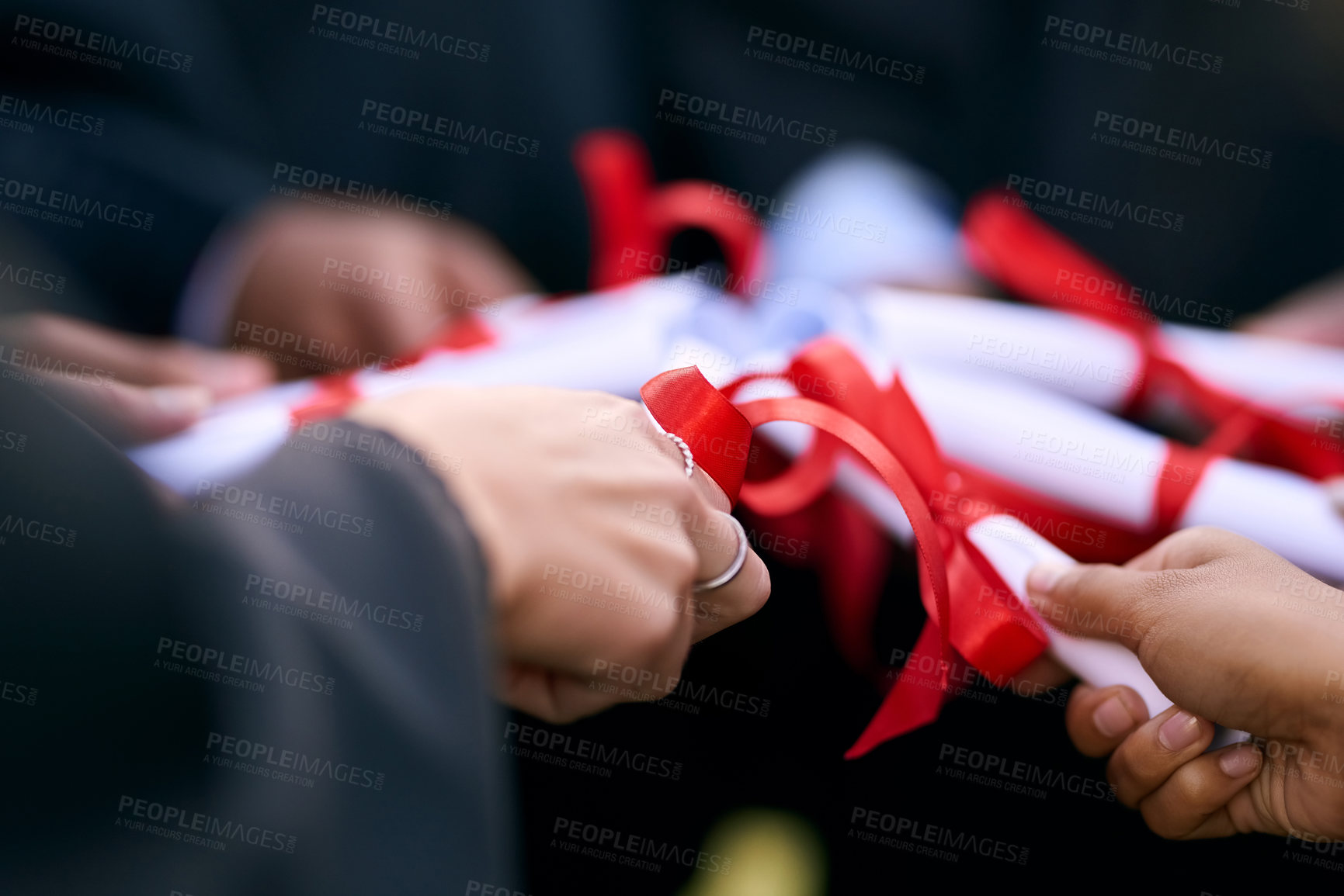 Buy stock photo Closeup shot of a group of university students holding their diplomas together on graduation day
