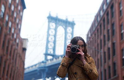 Buy stock photo Portrait of an attractive young woman taking pictures with a camera in the city