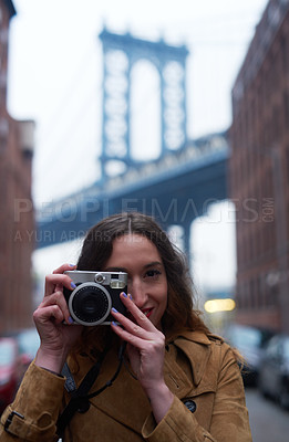 Buy stock photo Portrait of an attractive young woman taking pictures with a camera in the city