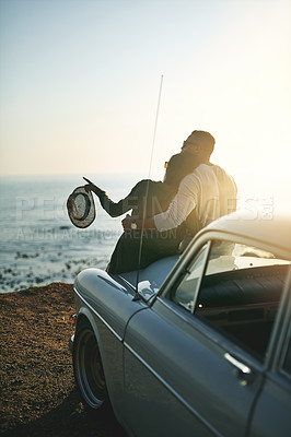 Buy stock photo Hug, pointing and road trip with couple at ocean together for holiday, travel or vacation in nature. Back, bonding or love with man and woman embracing outdoor for anniversary, honeymoon or romance