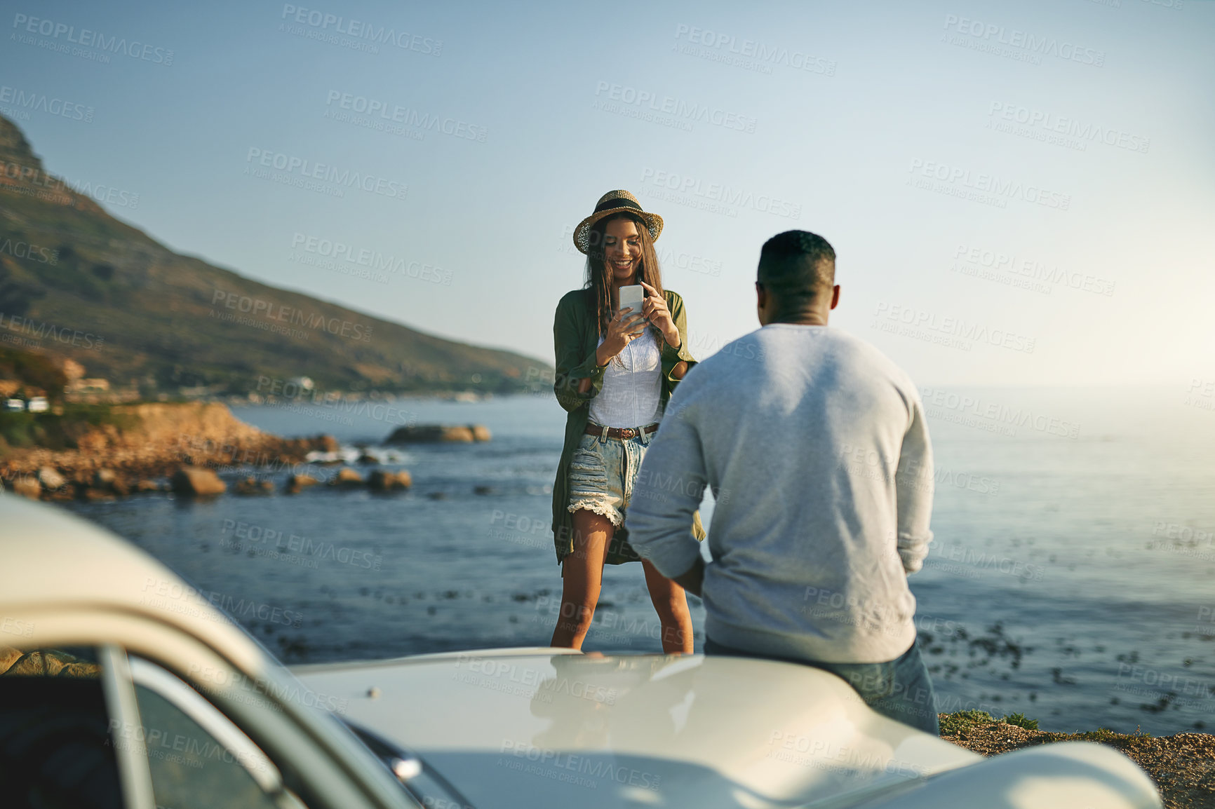 Buy stock photo Photograph, road trip and view with couple at ocean together for holiday, travel or vacation in nature. Love, smile and social media with man and woman outdoor for anniversary, honeymoon or memory