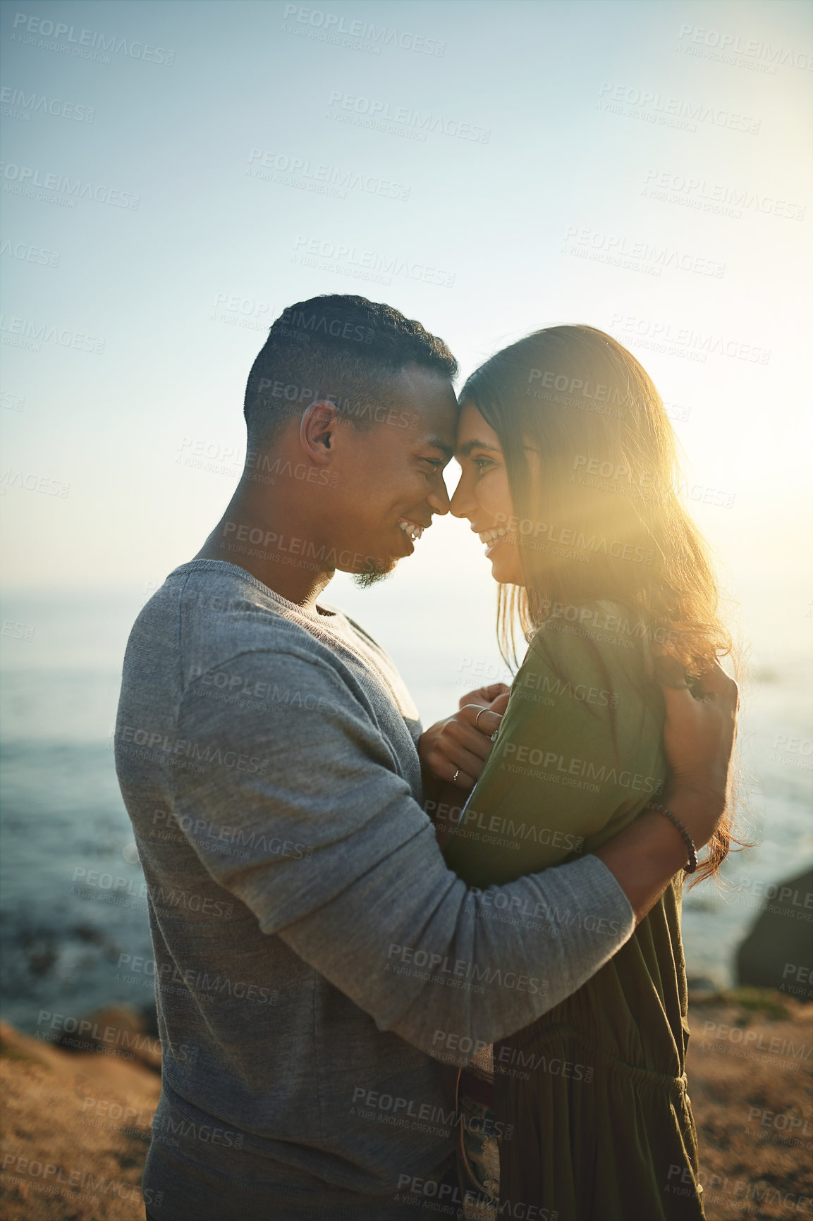 Buy stock photo Shot of a young couple on the beach at sunset