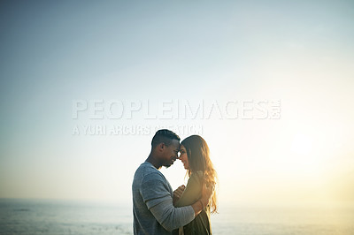 Buy stock photo Shot of a young couple on the beach at sunset