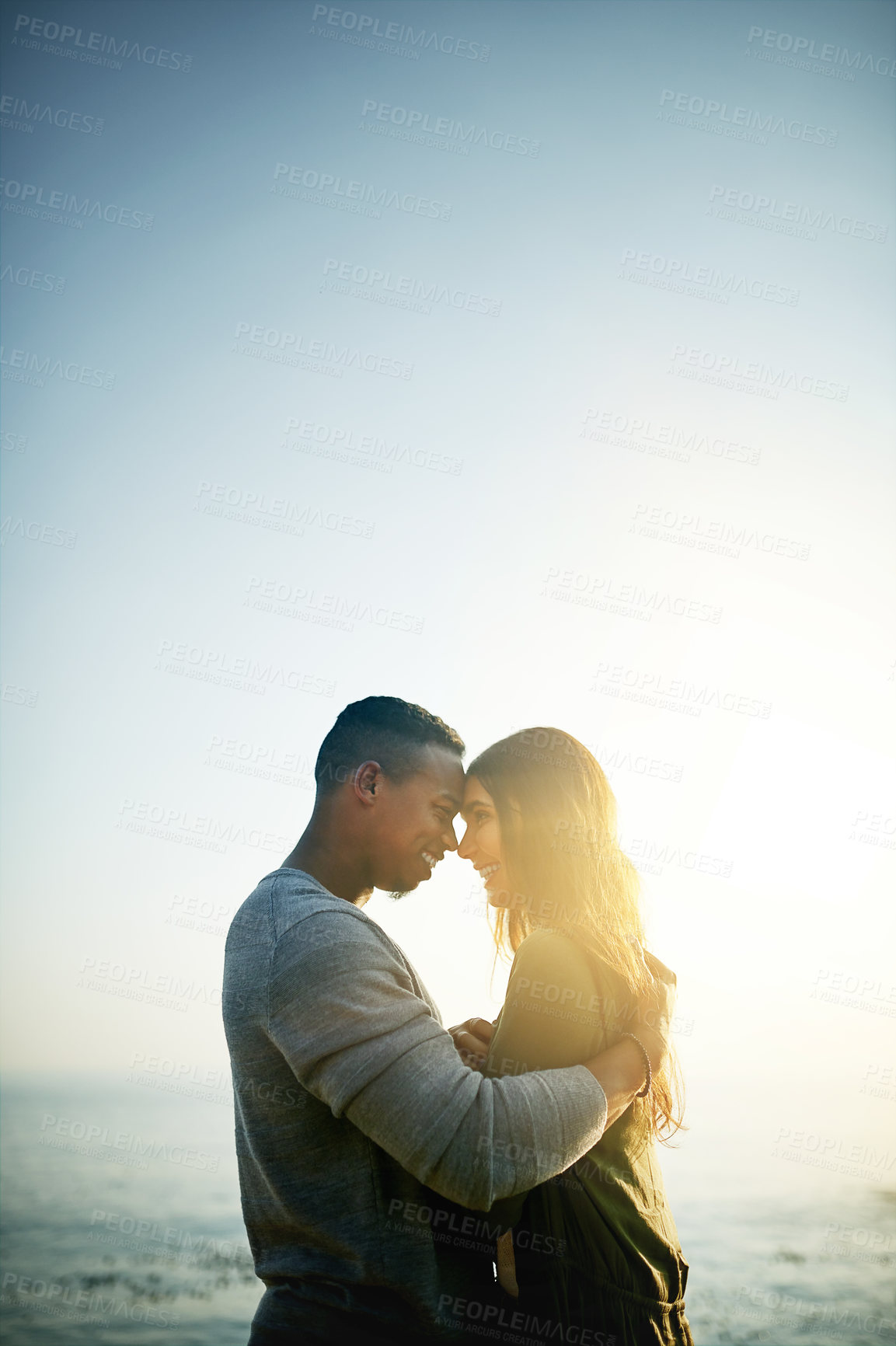 Buy stock photo Happy couple, hug and love with beach sunset or space for intimacy, embrace or holiday weekend together in nature. Young, man and woman with smile for bonding, romance or affection by ocean coast