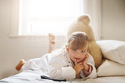 Buy stock photo Shot of an adorable little girl dressed up as a doctor and treating her teddy bear as a patient